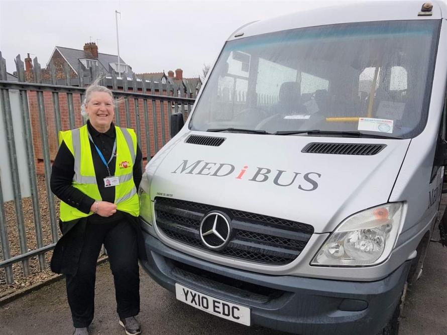Volunteer Driver Kay stands in front of community transport Medibus
