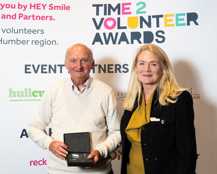 Peter standing with Smile's Chair of Trustees after having accepted the Award.
