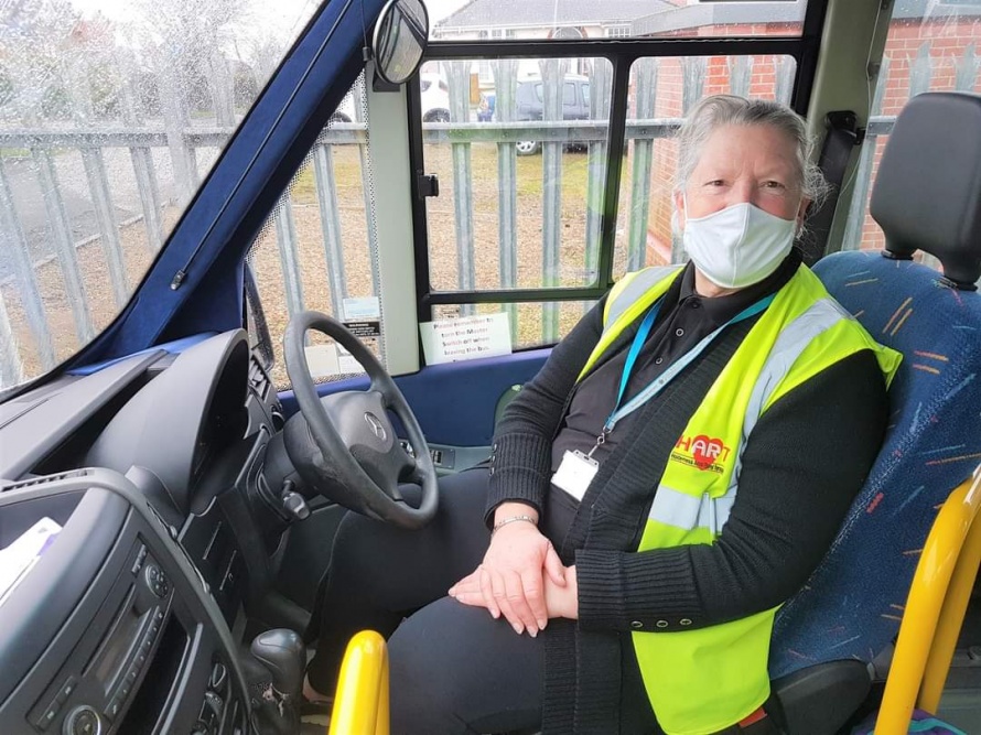Volunteer Driver Kay sits at the wheel in community transport bus
