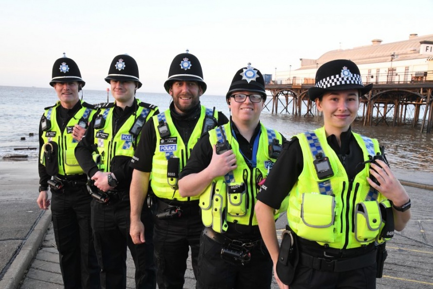 A group of Special Constable Volunteers in uniform and smiling for the photo 